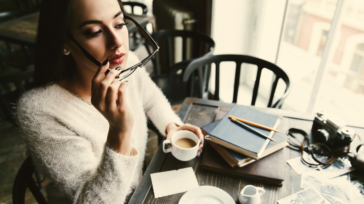 girl-puts-her-glasses-sitting-with-cup-coffee-cafe_82107300