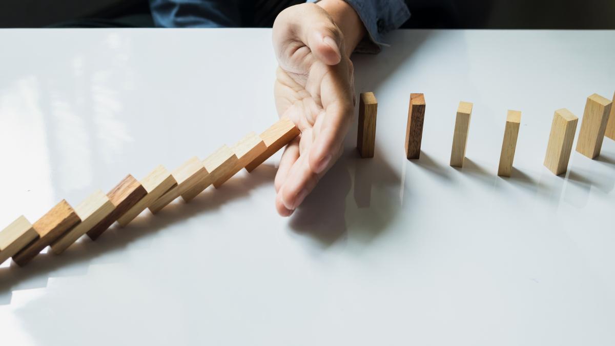 businessman-hand-stop-dominoes-continuous-toppled-risk-with-copyspace_83778000