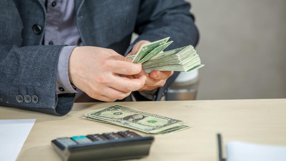 young-businessman-working-from-his-office-counting-cash-money_24399100