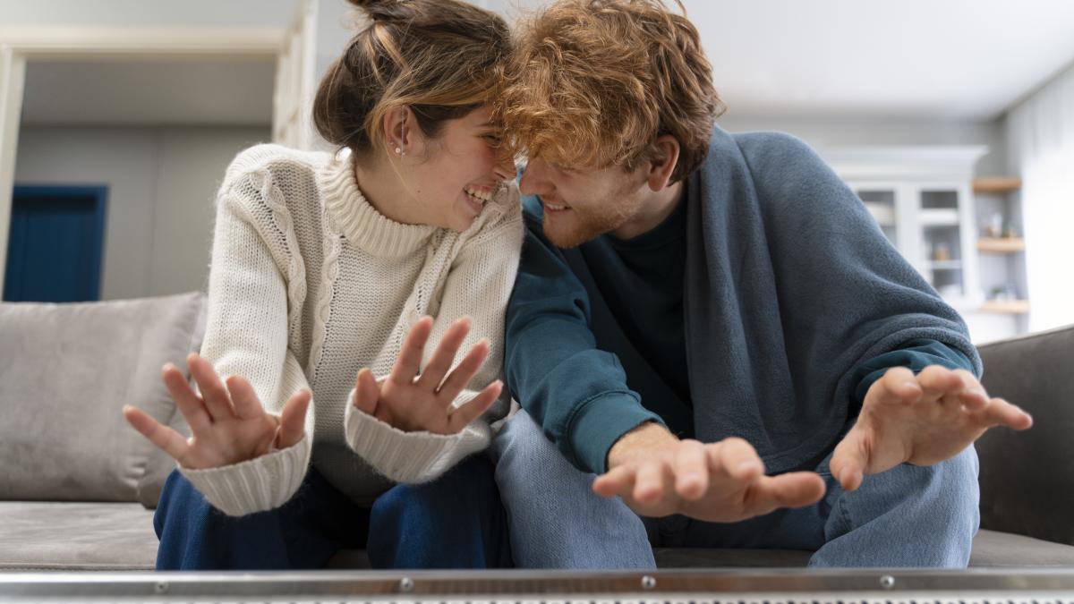 medium-shot-happy-couple-warming-up-with-heater_20697200