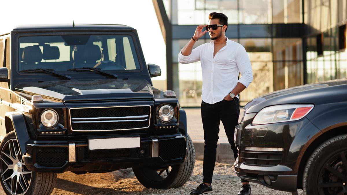 solid-asian-man-white-shirt-sunglasses-posed-near-black-mafia-suv-cars_16100100