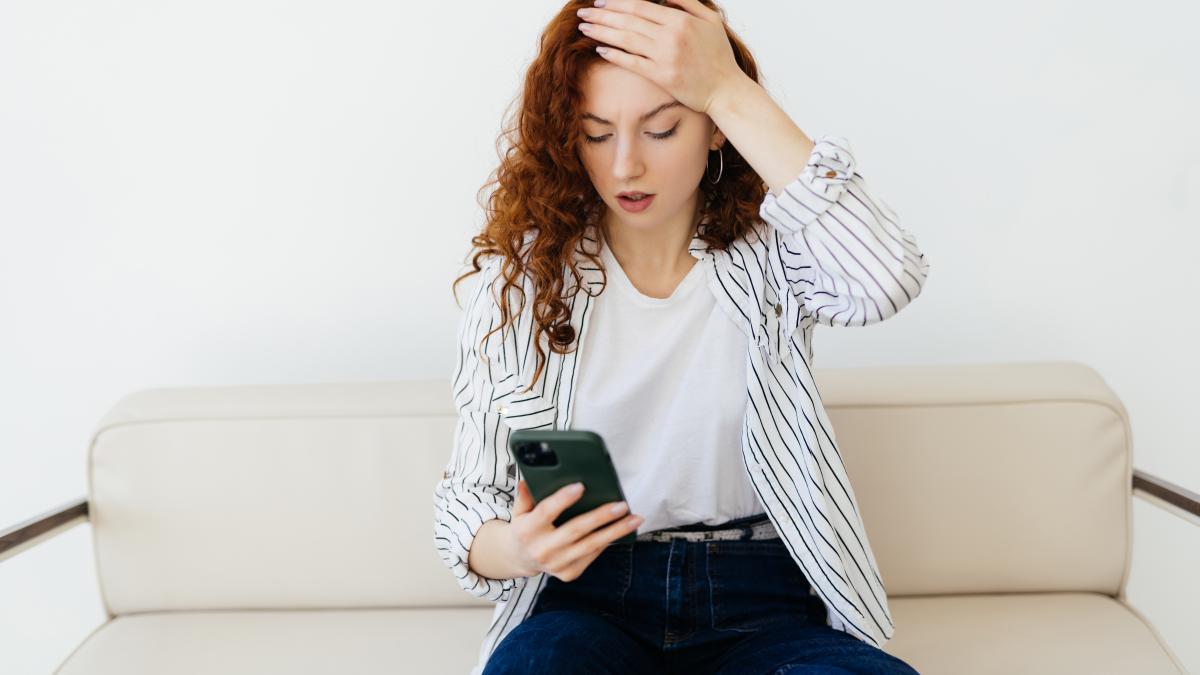 worried-woman-sitting-sofa-home-having-negative-phone-talk-hearing-bad-news-arguing_07955400