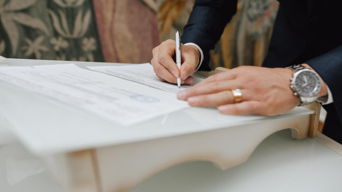 man-with-pen-signs-document_48296700