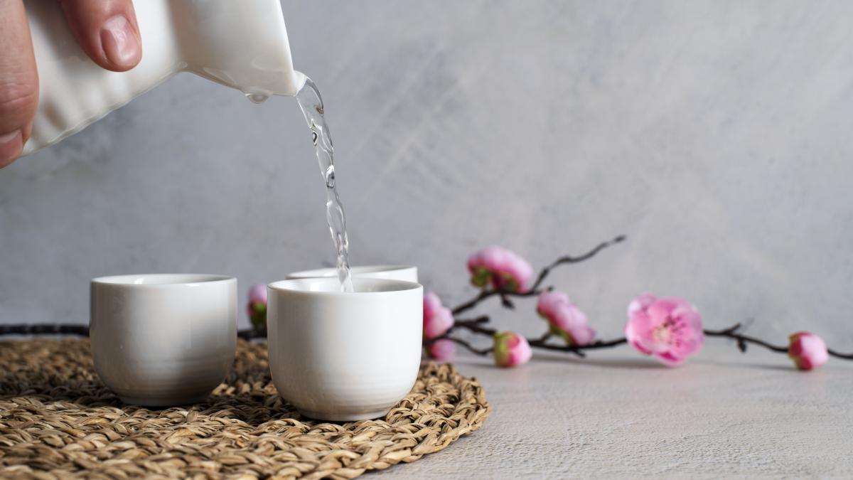 side-view-hand-pouring-drink-cups_01239400