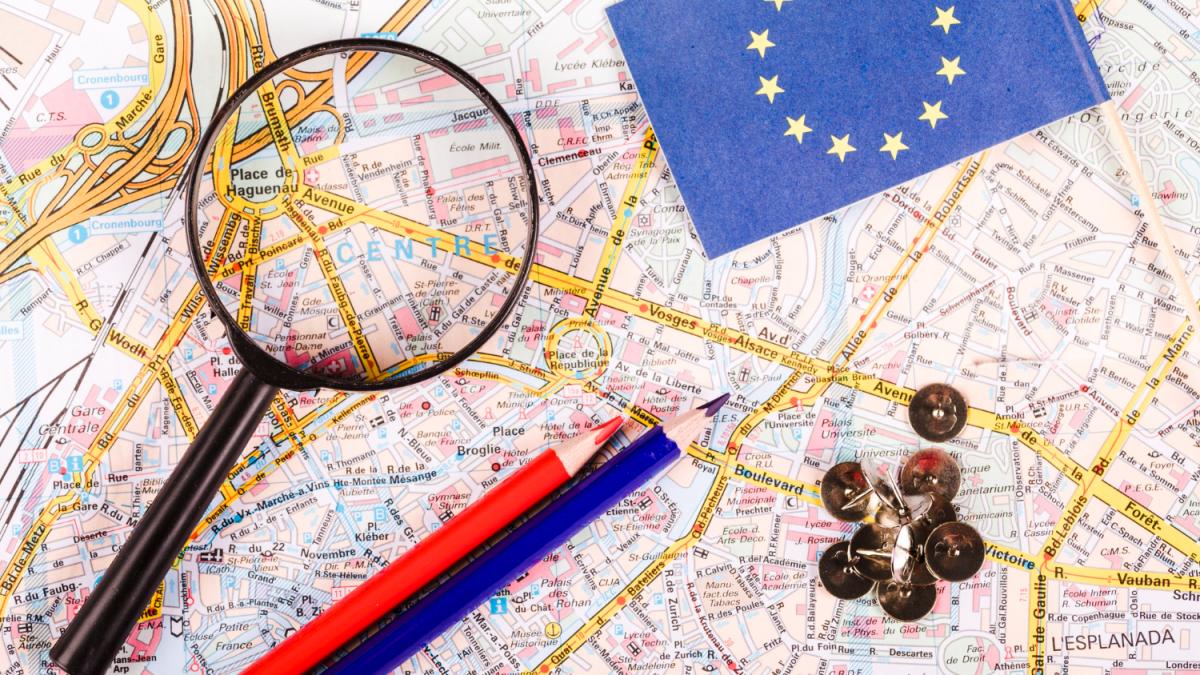 elevated-view-magnifying-glass-pushpins-pencils-flag-map_54772800