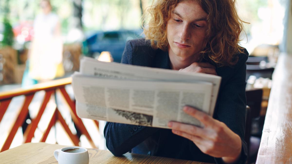 young-man-reading-newspaper_47070000