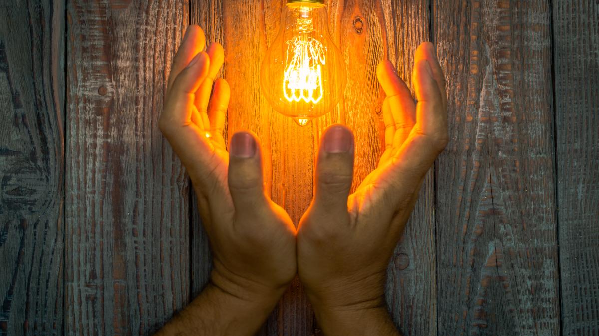 hands-lit-light-bulb_12570800