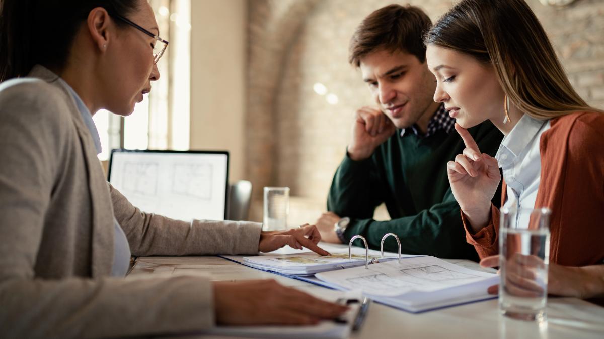 young-man-his-wife-examining-housing-plans-with-real-estate-agent-meeting-office_13928800