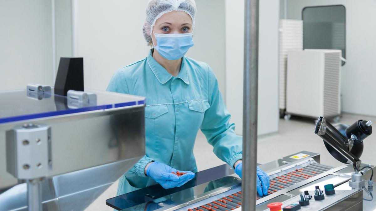 pharmacy-industry-woman-worker-protective-clothing-operating-production-tablets-sterile-working-conditions_54993500