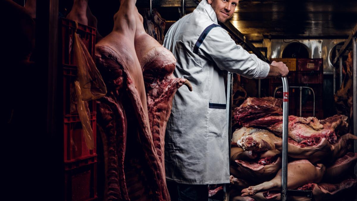 butcher-white-work-shirt-standing-refrigerated-warehouse-midst-meat-carcasses_09314300