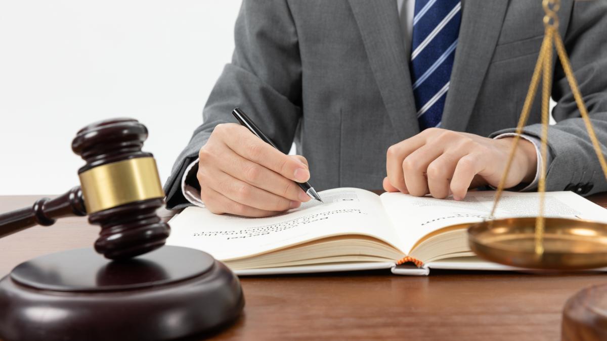 closeup-shot-person-writing-book-with-gavel-table-2_65688600