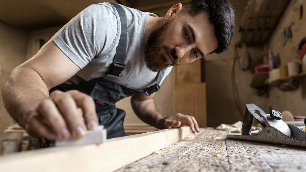 carpenter-cutting-mdf-board-inside-workshop_13023000