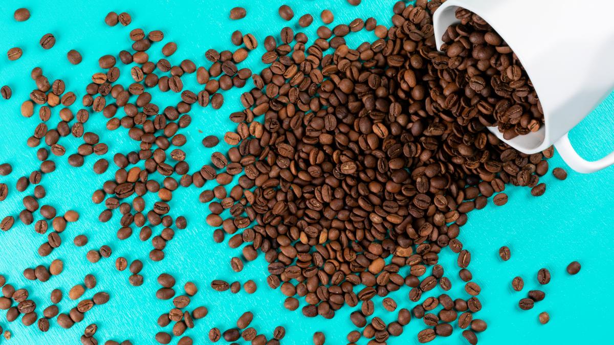 top-view-coffee-beans-with-cup-blue-surface_45137400