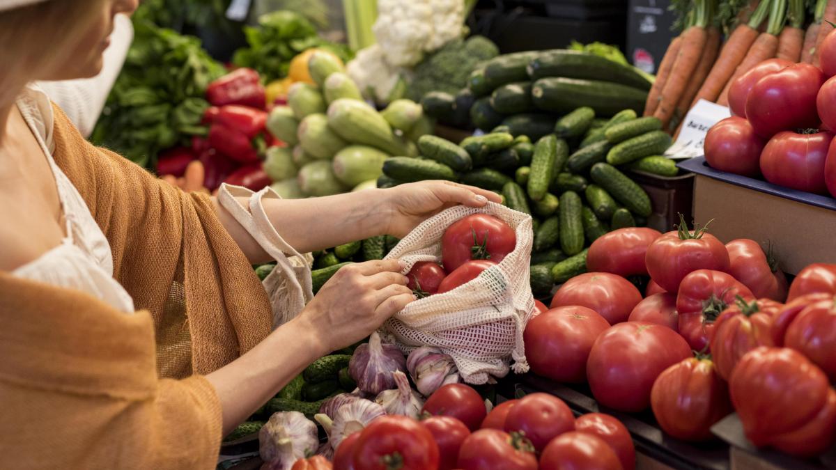 woman-buying-tomatoes-from-market-place_47102400
