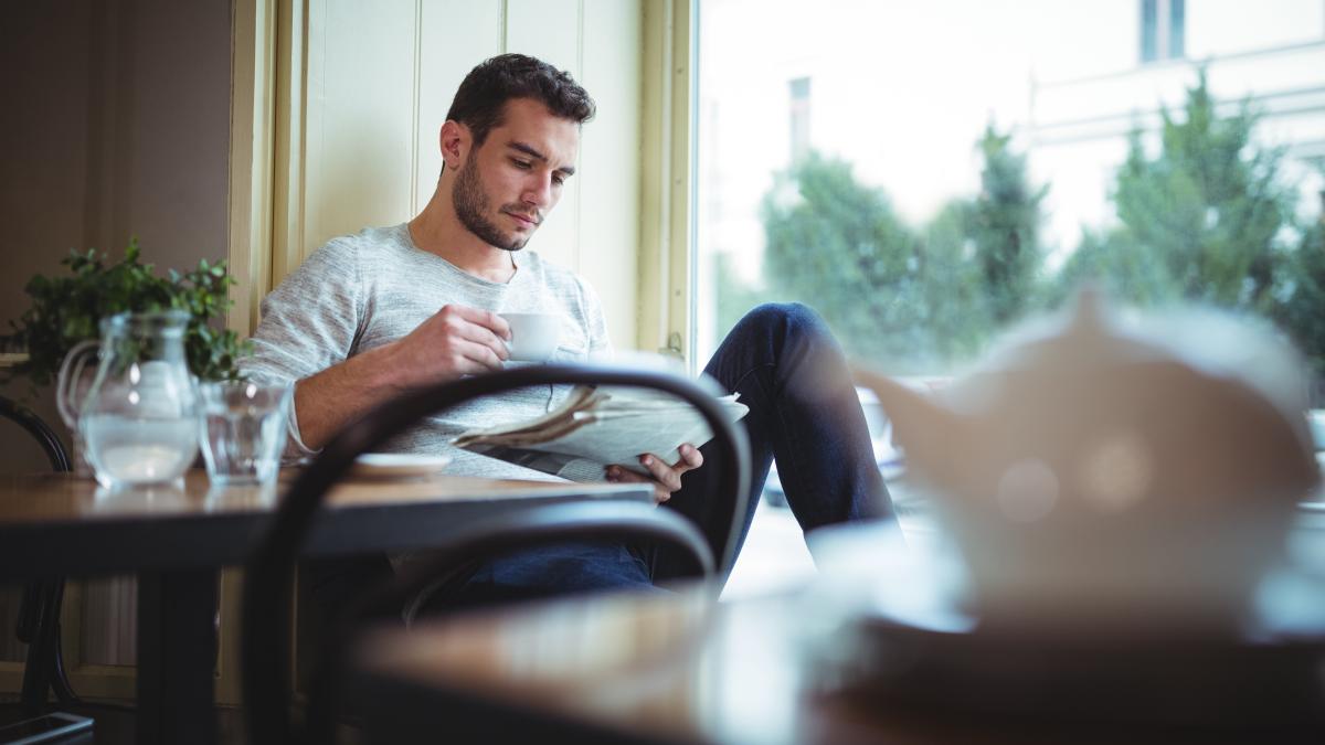 man-having-cup-coffee-while-reading-newspaper_25675700