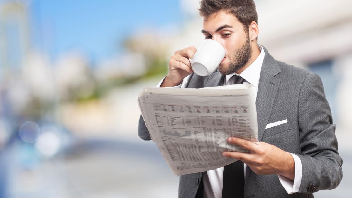worker-with-cup-coffee-reading-news_66295500