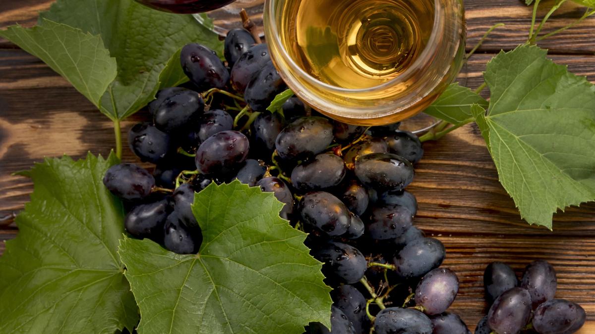 bunch-grapes-with-corkscrew-wooden-background_51627300