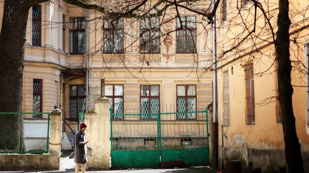 boy-grey-coat-red-hat-stands-street_33830000