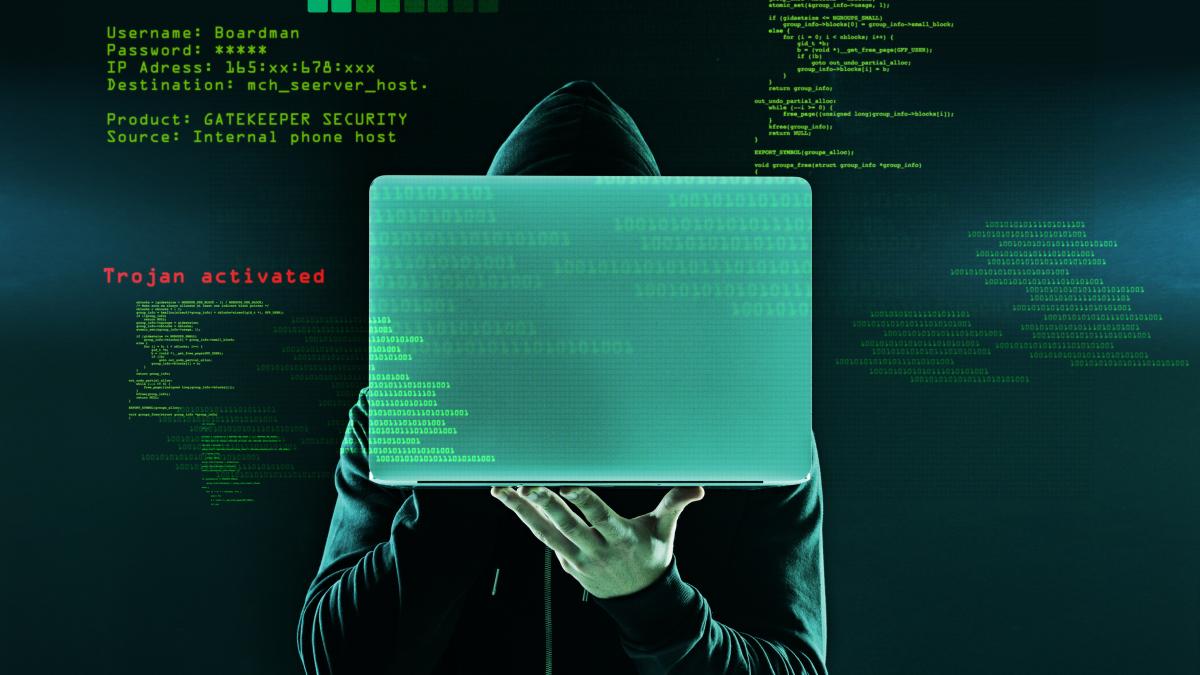 hes-just-found-his-victim-shot-unidentifiable-hacker-holding-up-laptop-against-dark-background_23782800