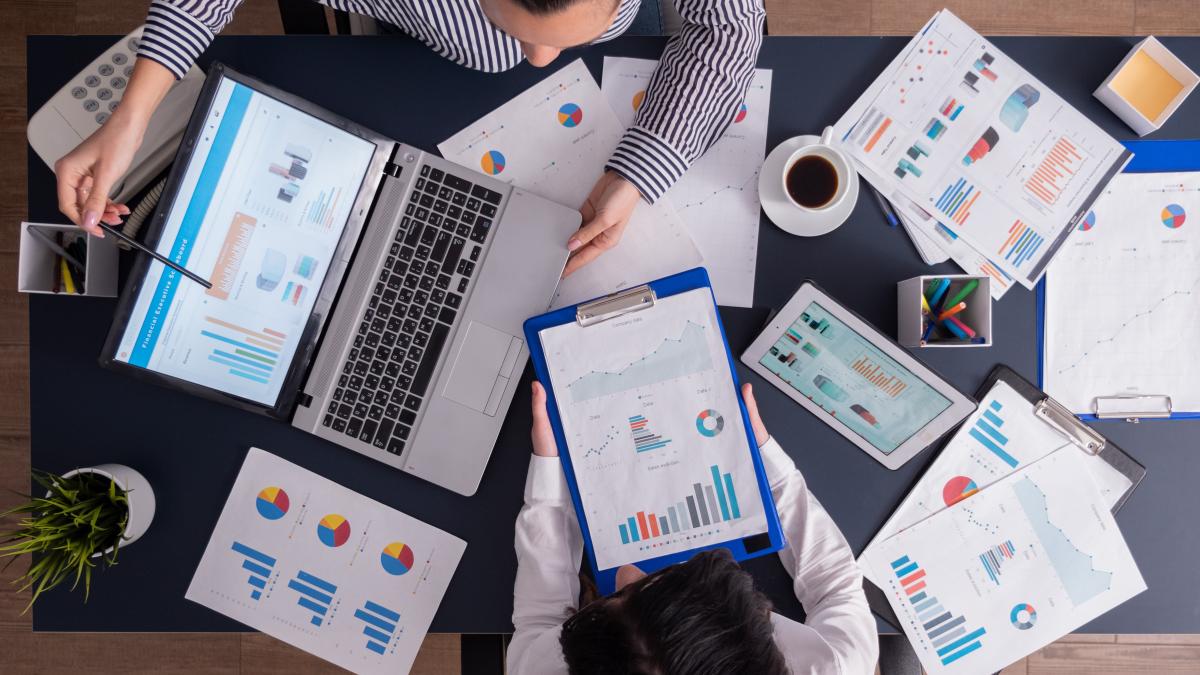 top-viewtop-view-manager-employee-doing-teamwork-business-office-looking-charts-laptop-display_22906300