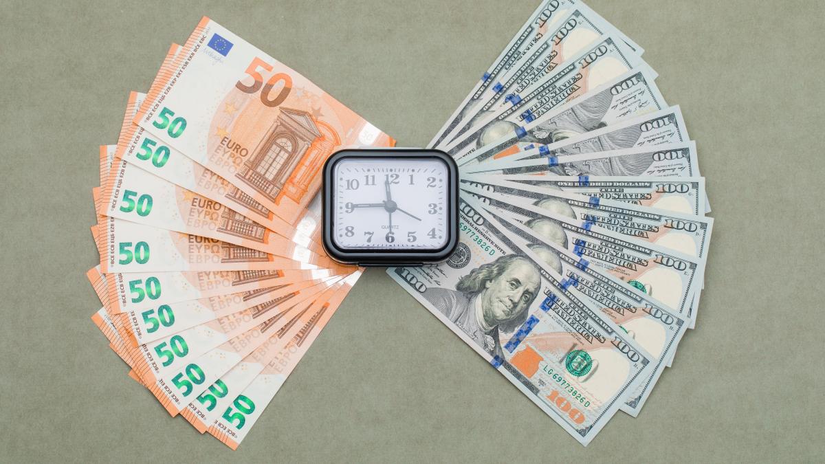 clock-dollar-euro-bills-green-grey-table_58823000