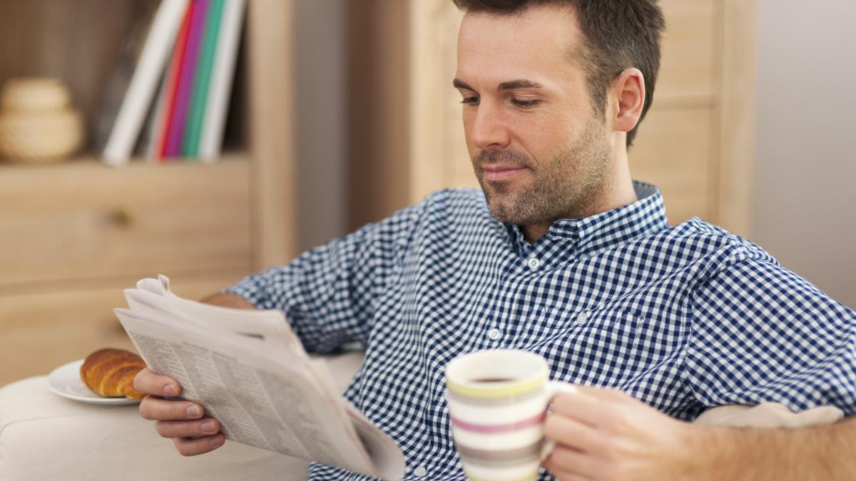 smiling-man-with-newspaper-cup-coffee_44925400
