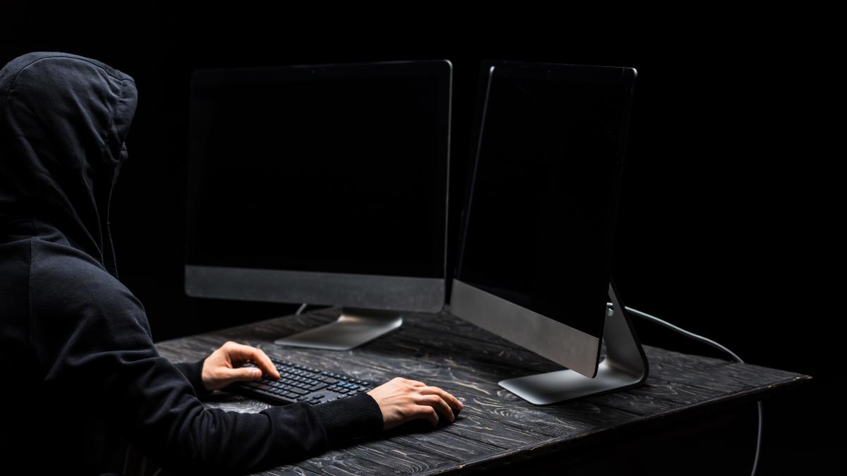 hacker-using-computer-mouse-looking-computer-monitors-with-blank-screen-isolated-black_74875000