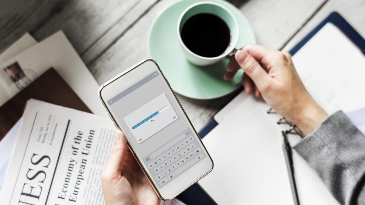 hands-holding-downloading-mobile-phone-with-coffee-cup-beverage-1_22004500