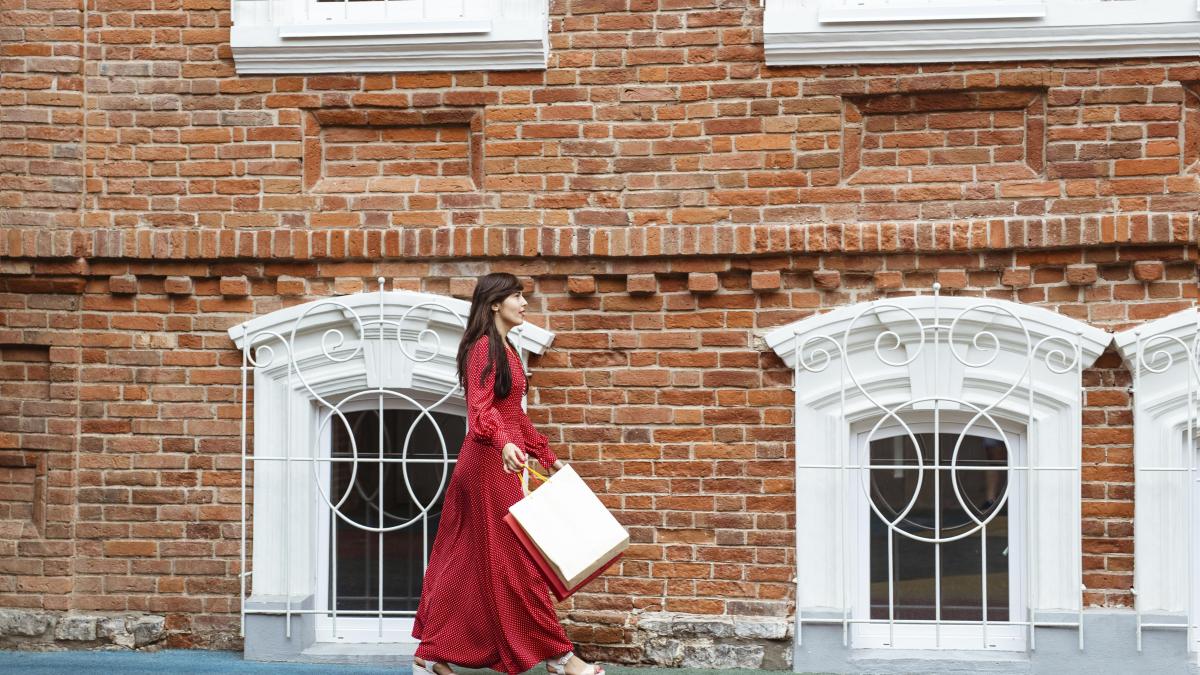 side-view-woman-walking-with-shopping-bags_73989300