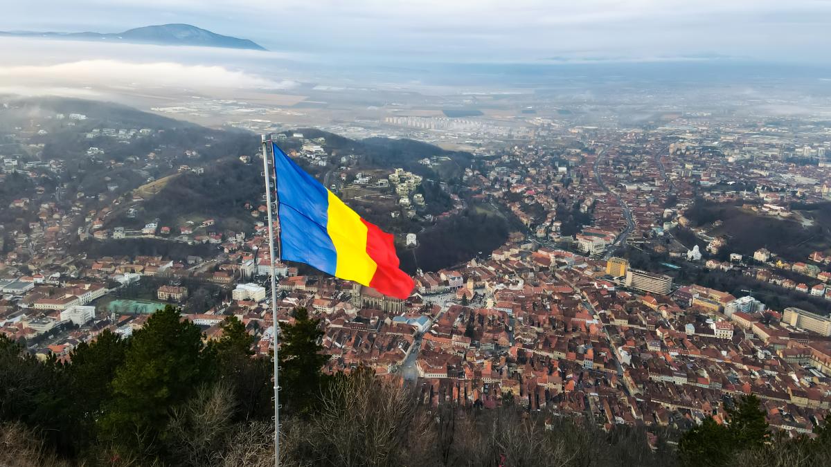 national-flag-top-hill-near-barsov-bare-trees-low-clouds-cityscape-romania_07949000