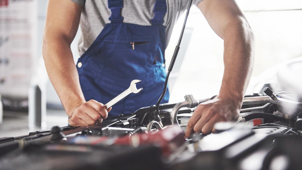 muscular-car-service-worker-repairing-vehicle_56911000