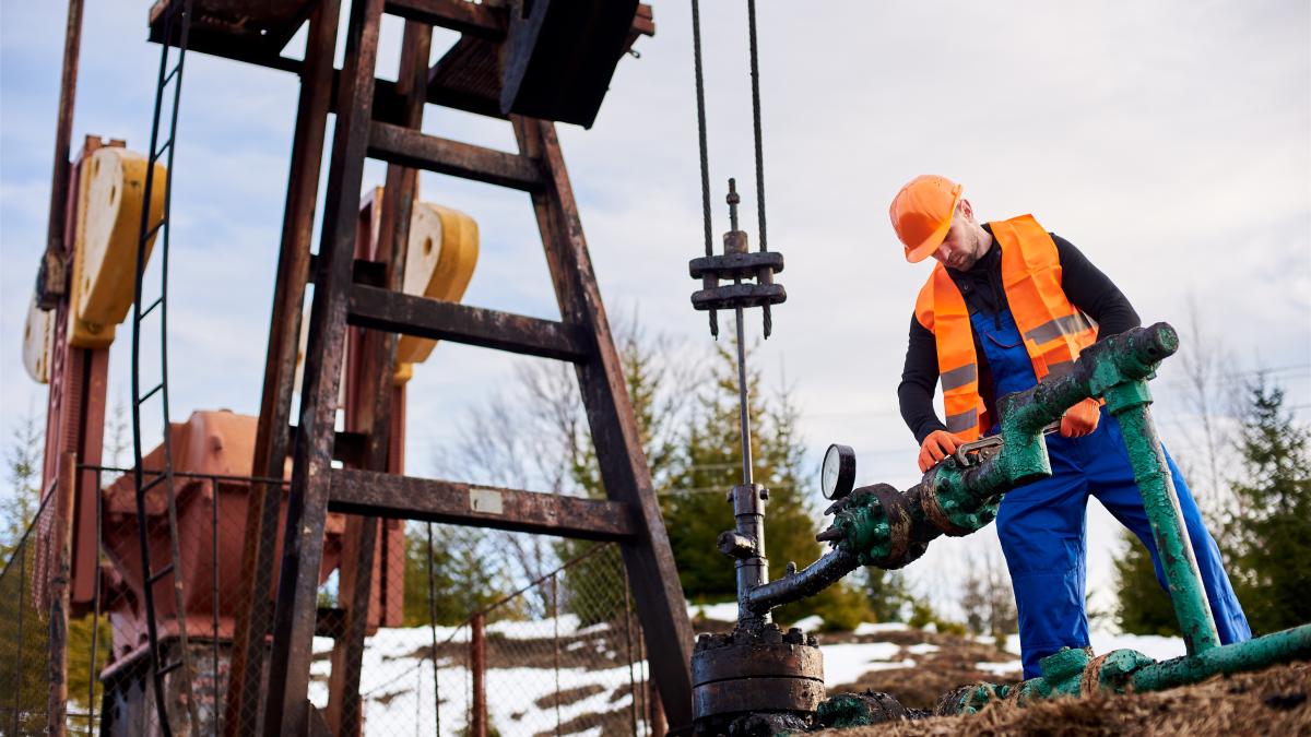 oil-worker-orange-uniform-helmet-working-with-pipe-wrench-near-oil-pump-jack-1_76021200