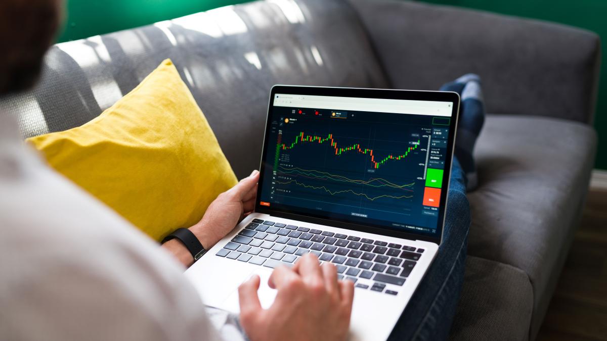 trading-finances-young-man-resting-couch-while-checking-stock-market-laptop_93163700