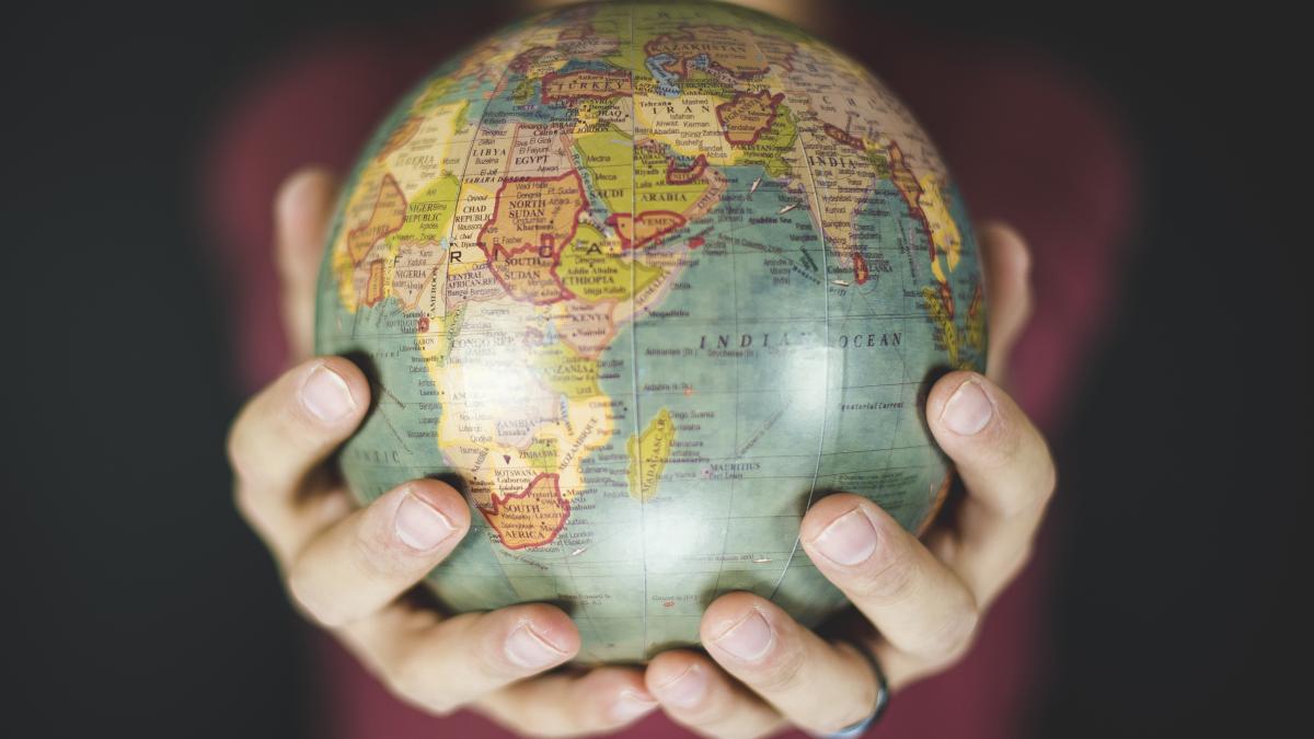 closeup-shot-person-holding-small-globe-with-two-hands_72687400