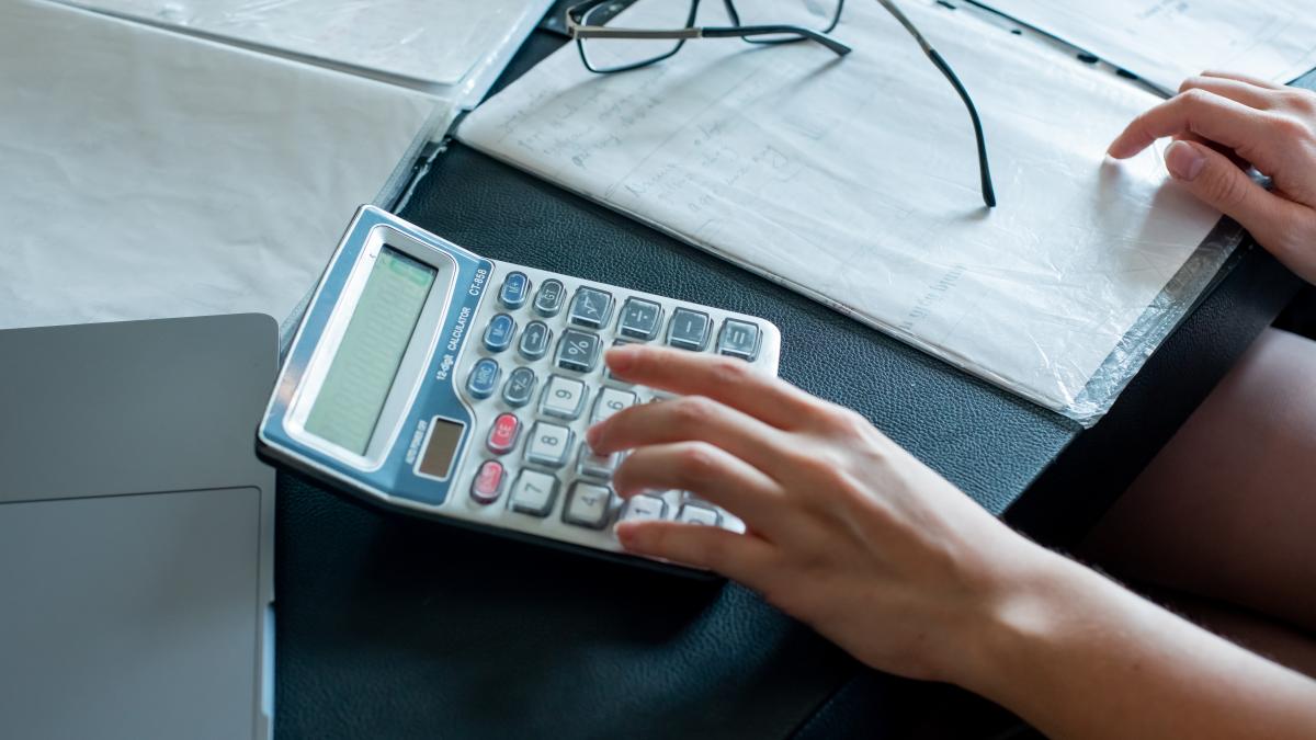 close-up-view-female-hands-doing-calculations-documents-with-glasses-office-desk-working-process-office-concept_49510100