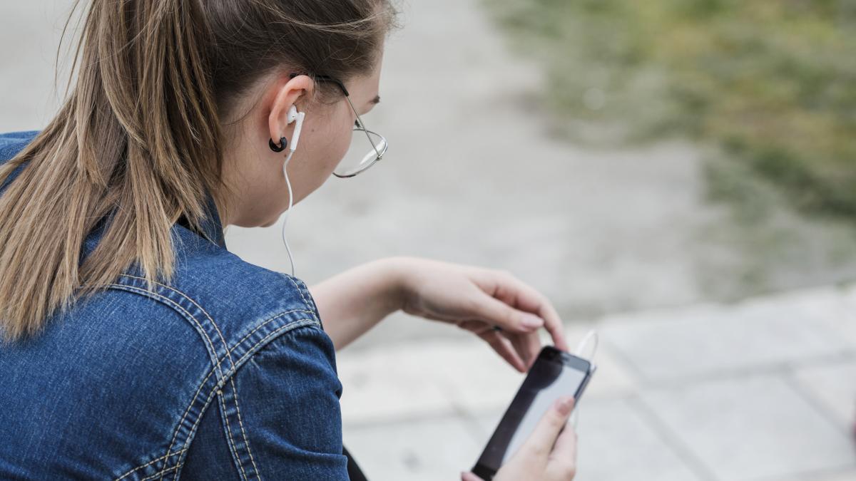woman-earphones-using-smartphone-park_49990200