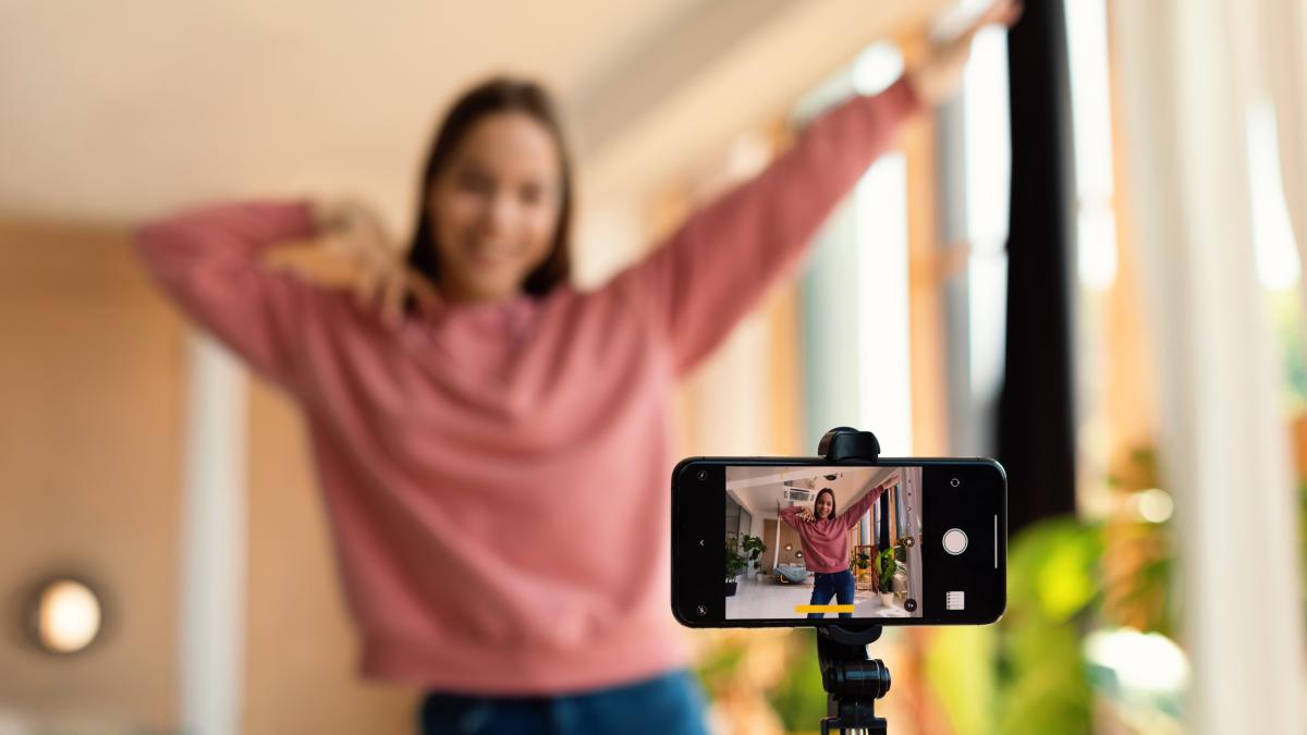 modern-content-creator-excited-teen-girl-filming-video-blog-social-network-using-cellphone-tripod-broadcast_45875500