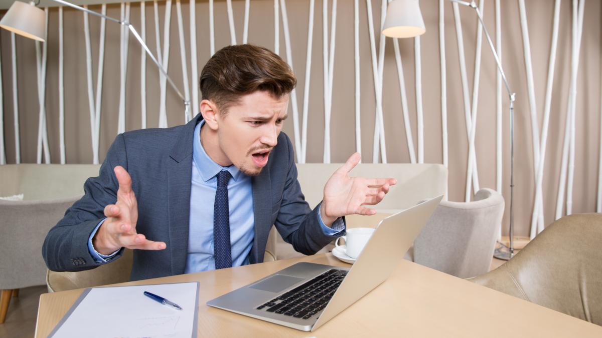 indignant-businessman-working-laptop-cafe_79393600