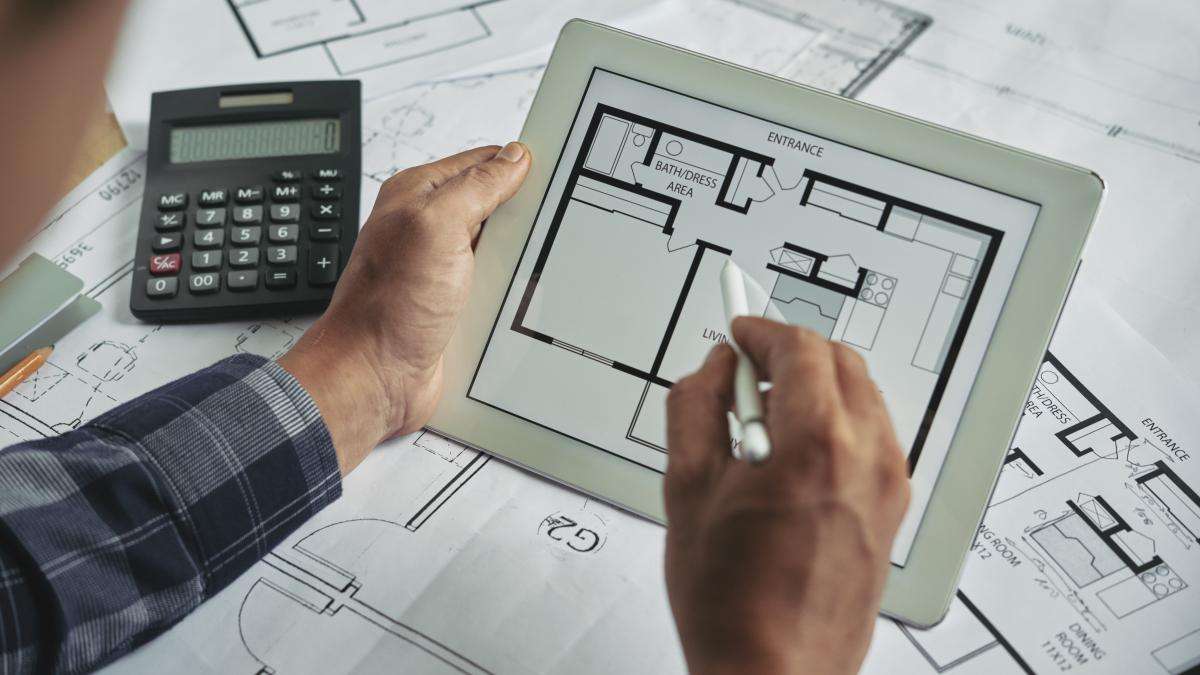 cropped-view-male-hands-holding-digital-pad-examining-blueprint