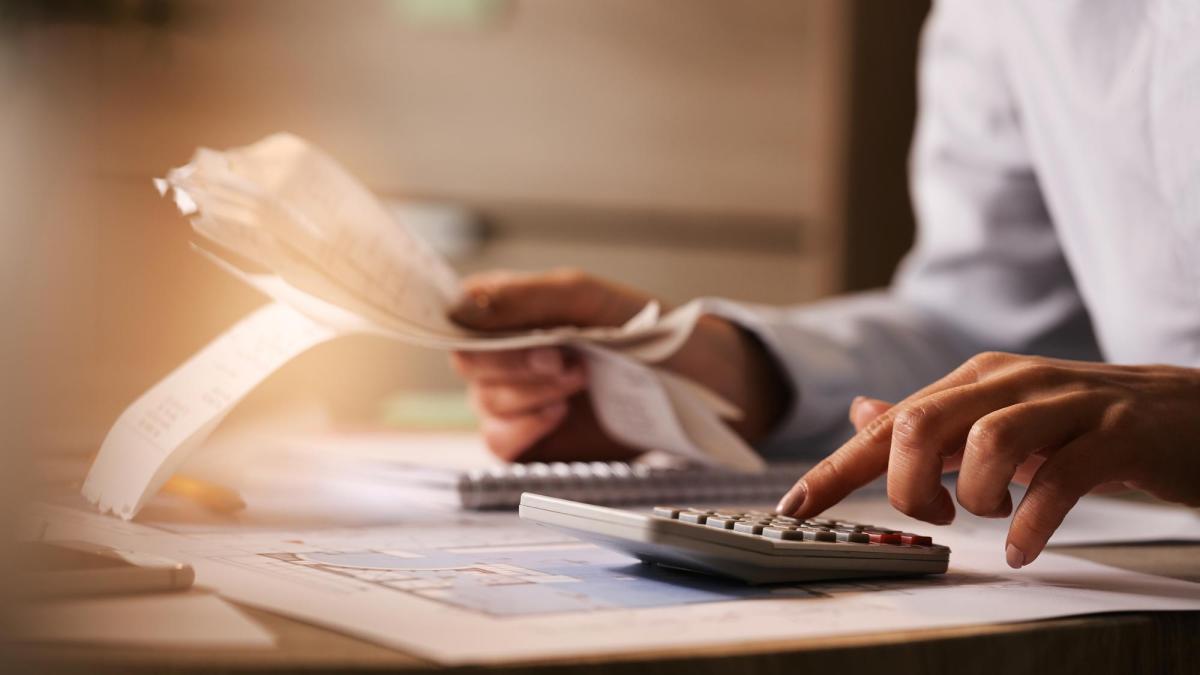 closeup-economist-using-calculator-while-going-through-bills-taxes-office-2_89635200
