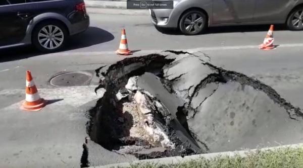 O mașină a fost înghițită de o groapă apărută pe o stradă din București
